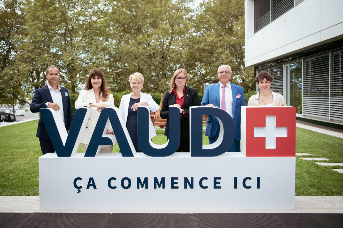 Portrait de groupe du comité directeur de Vaud Promotion posant derrière un logo géant affichant: "Vaud, ça commence ici"